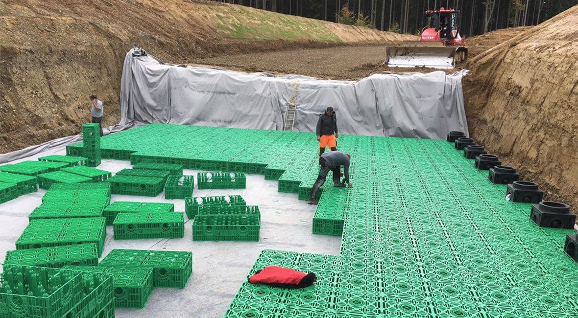 Drei Männer arbeiten an einem Regenwassermanagementsystem in einem Graben (Foto)